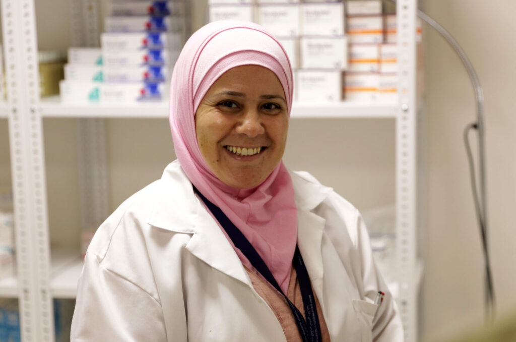 Sinno in her pharmacy smiles at the camera