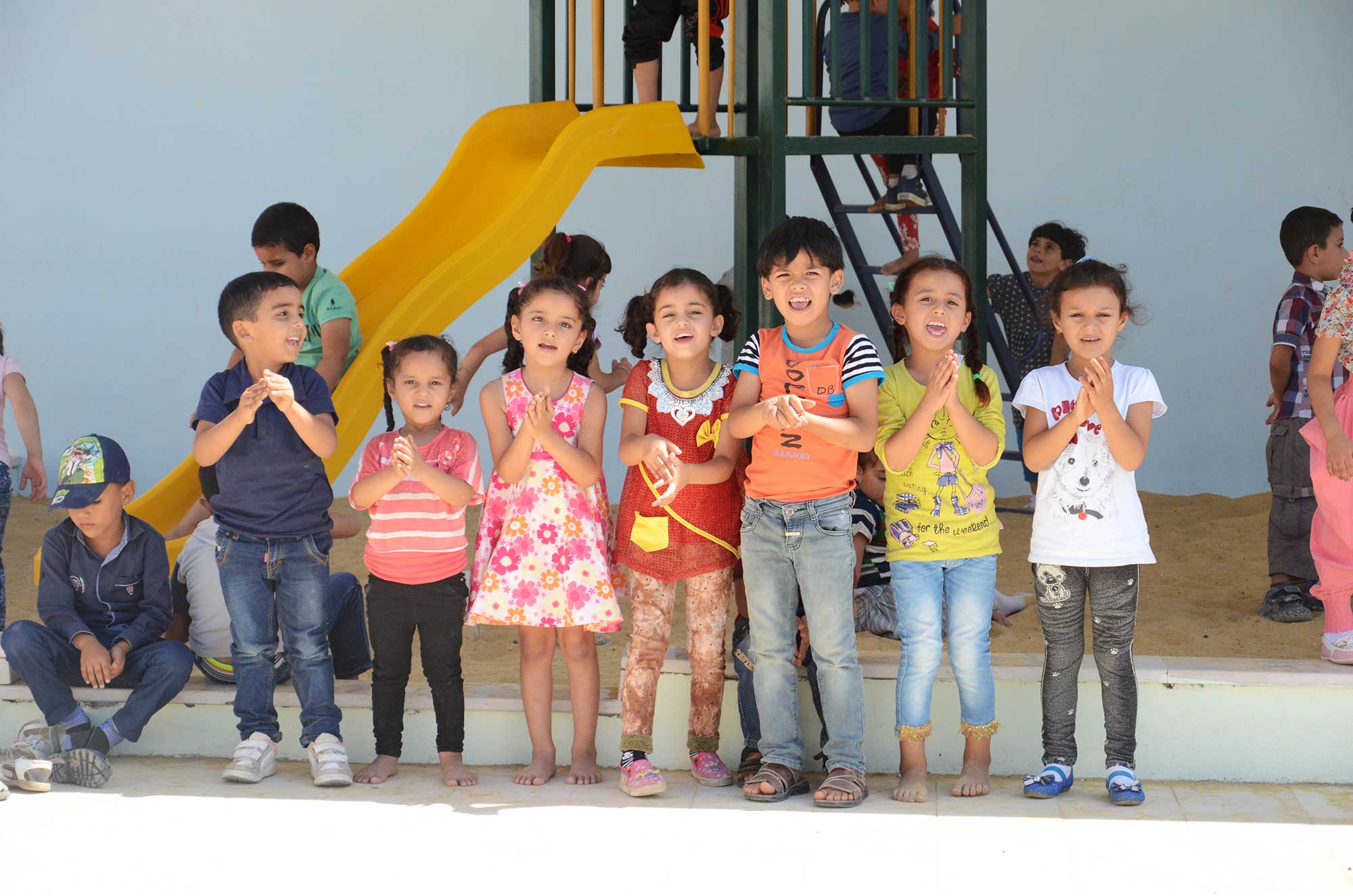 Palestinian children stand in front of the new preschool in Al Majd.