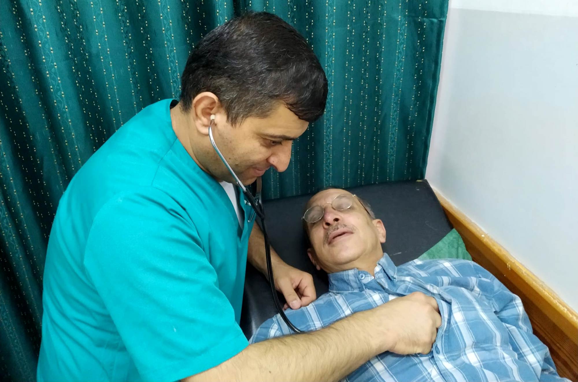 Dr. Ismail Tmaizi inspects his patient, Fadel. Donated medicines support health in Palestine.